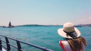 Slow Motion: güzel kız, Üsküdar kasabasında Bosphorus and Maidens Kulesi 'nin fotoğraflarını çeker, Istanbul, Türkiye