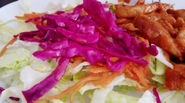 Yavaş hareket: ahşap masa üzerinde kase taze karışık yeşil salata yakın