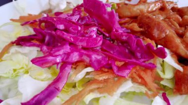 Yavaş hareket: ahşap masa üzerinde kase taze karışık yeşil salata yakın