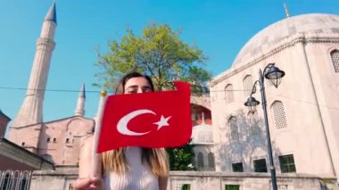 Güzel genç kızlar, İstanbul 'da eski bir binanın önünde Türk bayrağı dalgaları, Türkiye, seyahat konsepti