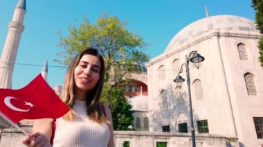 Yavaş hareket: güzel genç kızlar, İstanbul 'da eski bir binanın önünde Türk bayrağı dalgaları, Türkiye, seyahat konsepti