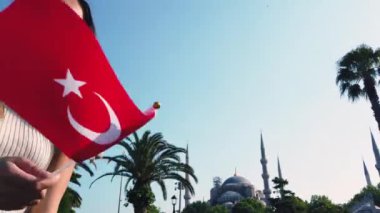 Güzel genç kızlar, İstanbul 'da Sultan Ahmed veya Sultanahmet Camii görünümü, Türkiye, seyahat konsepti ile Türk bayrağı dalgaları