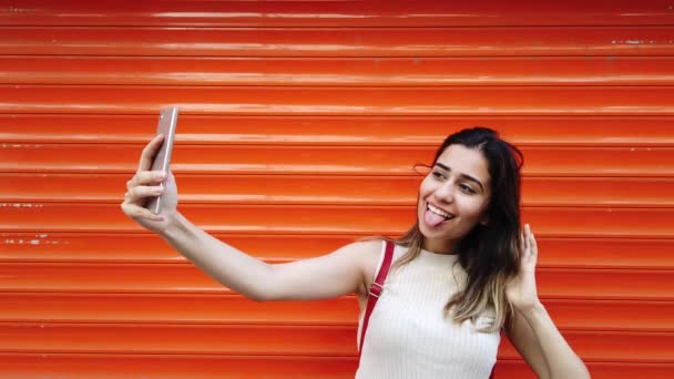 Movimento Lento Menina Bonita Leva Selfie Com Smartphone Frente Laranja — Vídeo de Stock