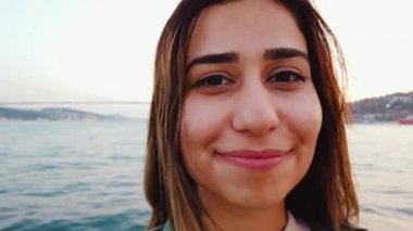 Güzel genç kız dalgalar Türk bayrağı, İstanbul, Türkiye 'de boğaz ve Simgesel yapılar manzaralı bir tekne turu yaparken.