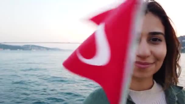 美丽的年轻女孩挥舞土耳其国旗 而有船游览博斯普鲁斯海峡和地标在土耳其伊斯坦布尔 — 图库视频影像