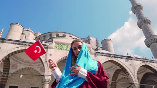 슬로우 셔츠에 매력적인 아름다운 소녀는 이스탄불술탄 모스크의 전망터키 국기를 — 비디오