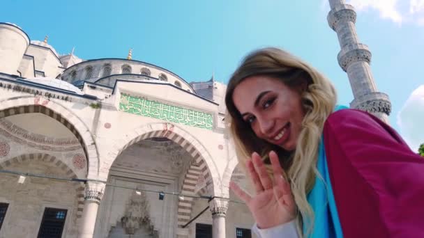 슬로우 셔츠의 매력적인 아름다운 소녀는 이스탄불에서 모스크의 전망과 셀카를 걸립니다 — 비디오
