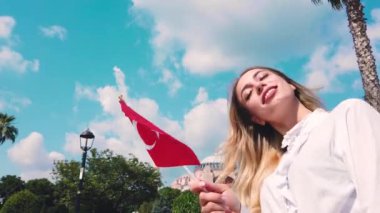 Slow Motion:Güzel genç kız, İstanbul'da eski bir binanın önünde selfie çekiyor ve Türk bayrağı sallıyor,Türkiye,Seyahat konsepti