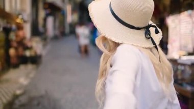 Çekici genç güzel kız yaz aylarında dar sokakta erkek arkadaşının kolunu çeker. Takip et beni.