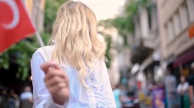 Yavaş Hareket:Çekici genç güzel kız Galata Kulesi önünde Türk bayrağı sallıyor, İstanbul'un popüler bir simgesi,Türkiye.