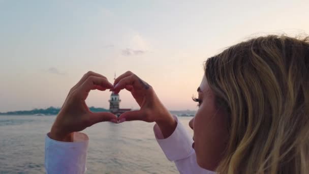 Slow Motion Beautiful Girl Makes Heart Shape View Maiden Tower — Stock Video