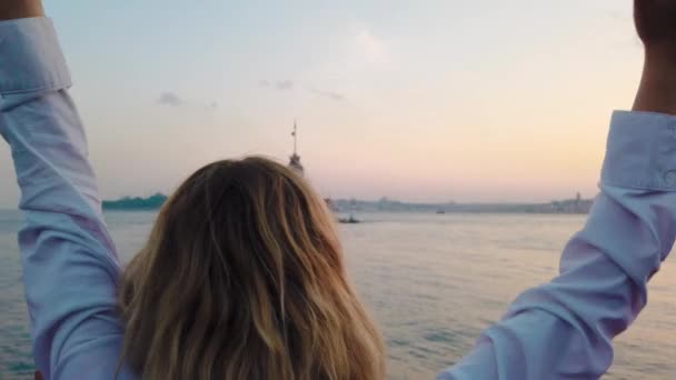 慢动作 美丽的女孩享受博斯普鲁斯海峡的日落景色 在伊斯坦布尔的背景看少女塔 — 图库视频影像