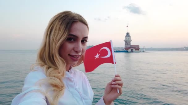 慢动作 迷人的漂亮女孩挥舞土耳其国旗 欣赏土耳其伊斯坦布尔博斯普鲁斯海峡和少女塔的日落景色 — 图库视频影像