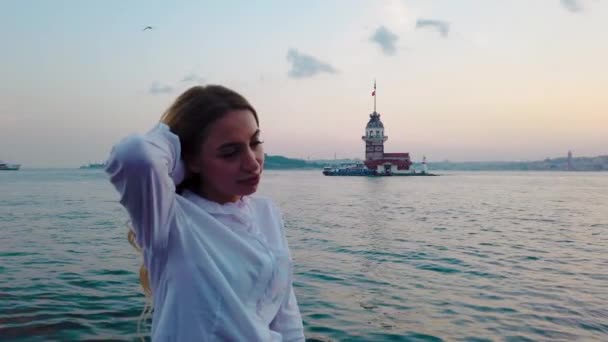 慢动作 美丽的女孩享受博斯普鲁斯海峡的日落景色 在伊斯坦布尔的背景看少女塔 — 图库视频影像