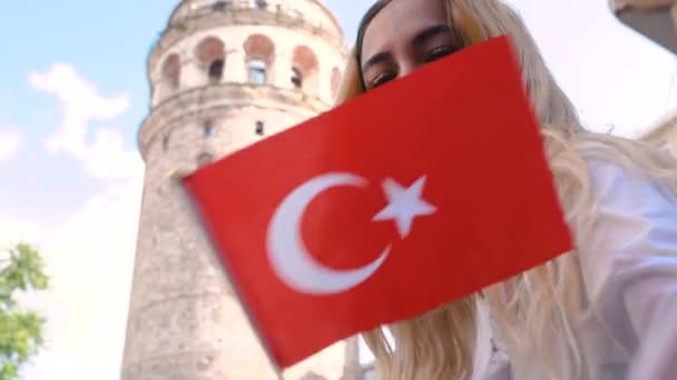 慢动作 迷人的年轻漂亮女孩在土耳其伊斯坦布尔著名的地标加拉塔塔前挥舞土耳其国旗 — 图库视频影像