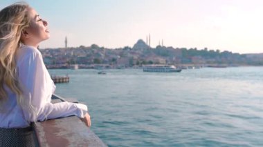 Ultra Yavaş Hareket:Galata Köprüsü'nün üzerinde duran güzel kız, İstanbul,Turkey.Traveler konseptinde Boğaz manzarasına sahiptir