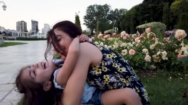 Mutter und Tochter umarmen sich und haben Spaß im Park