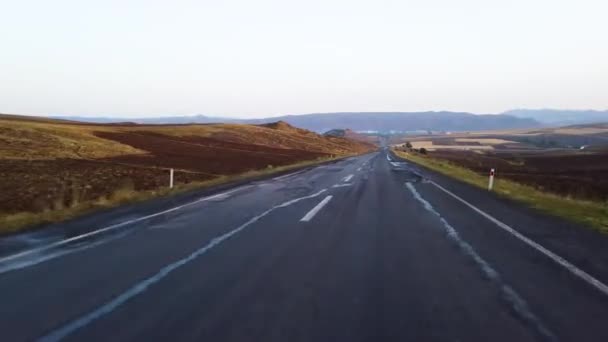 日没や日の出時に地平線に通じる空の丘陵道路の車内からの眺め — ストック動画