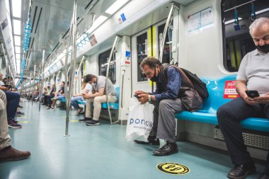 Tanımlanamayan Türk halkı, Türkiye 'nin İstanbul kentindeki Marmaray treninde nakledilirken sosyal uzaklık politikası için Covid-19' dan korunmak amacıyla maske takıyor: 16 Haziran 2020