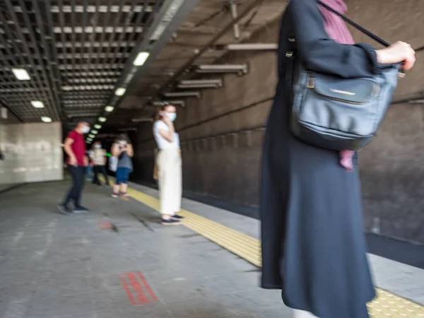 Blurred image: people wear masks to protect against covid-19 for social distancing policy while waiting Marmaray train in Istanbul,Turkey