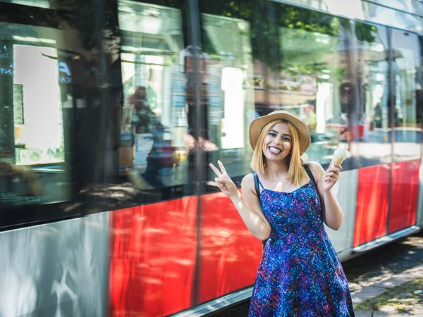 イスタンブール トルコを背景に路面電車が動いている間 ファッショナブルな服を着た美しい若い女の子がポーズをとっています — ストック写真