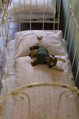 Bir üzgün ve yoksul çocukluk kavramı. Karanlık bir odada küçük bir çürük yatakta yalan yıpranmış eski el yapımı oyuncak.