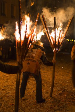 Chienbaese Festivali. İsviçre, Liestal, Rathausstrasse 25, 18 Şubat 2018. Festival katılımcıları yanan süpürge taşıyan eski kasabanın içinden omuzlarında ahşap günlükleri şeklinde.