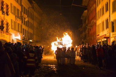 Chienbaese Festivali. İsviçre, Liestal, Rathausstrasse 25, 18 Şubat 2018. Festival katılımcıları eski kasabanın içinden ahşap yakma ile yığılmış bir vagon çekme.