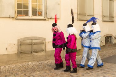 Basel karnaval. Martinsgasse, Basel, İsviçre - 21 Şubat 2018. Grup dört katılımcıların eski şehirde geziniyor