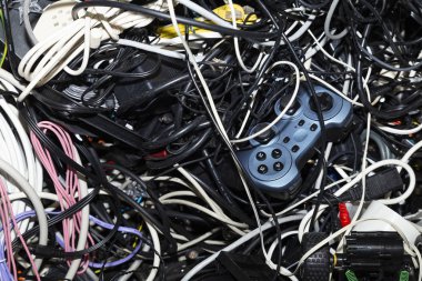 Elektronik hurda geri dönüşüm için bekleyen bir oyun konsolu denetleyicisi dahil olmak üzere dolaşık bir yığın Close-up