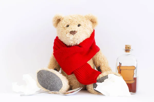 Sick teddy bear with vintage medicine bottle on white background