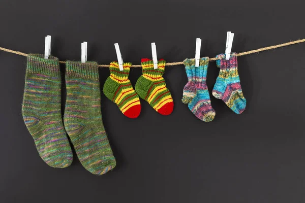 Calcetines de lana coloridos sobre una cuerda sobre fondo negro —  Fotos de Stock