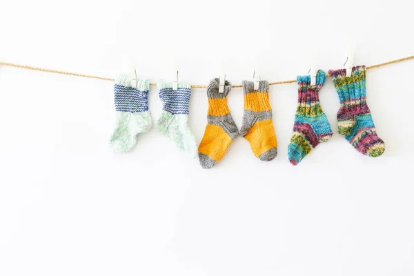 Цветные шерстяные носки на веревке на белом фоне — стоковое фото