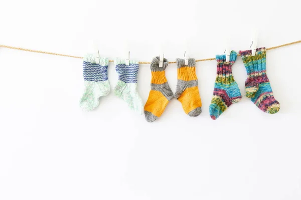 Chaussettes en laine colorées sur une corde sur fond blanc — Photo