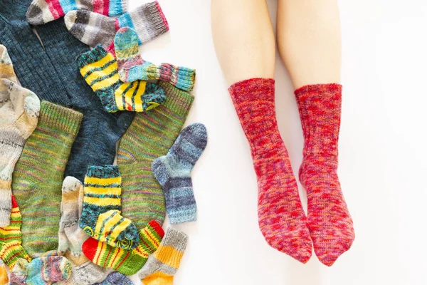 Colorful woolen socks and a pair of legs on white background