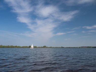 beyaz tekne yelken ilkbaharda bir göl ve beyaz bulutlar, gökyüzü