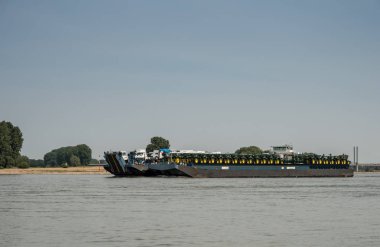 Nakliye gemisi Traktörler ve akış aşağı sürüş kamyonlar ile yüklenen Ren yakınındaki Rees, Almanya