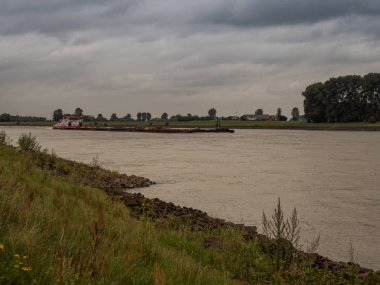 büyük gemi iterek Ren ters yönde Sürücüler, Grieth am Rhein, Almanya çok bulutlu bir günde