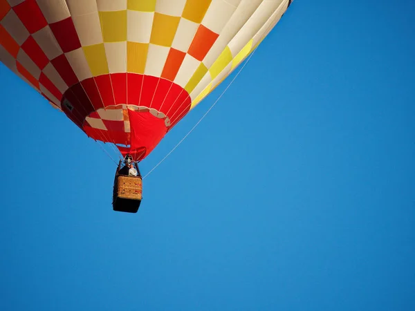 Sıcak hava balonu parlak mavi gökyüzüne uçuş