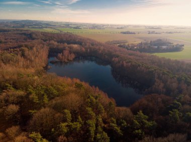 Sonbaharda ormanın ortasında bir gölün havadan görünümü, Almanya