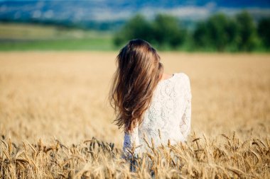 Kuru bir çim tarlasında duran bir insan.