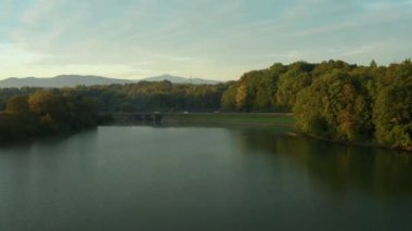 Sonbaharda barajda güzel bir sabah. Renkli ağaçlar ve yoldan geçen arabalarla.