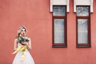 Elinde çiçek buketi pembe duvar zemin üzerine güzel gelin