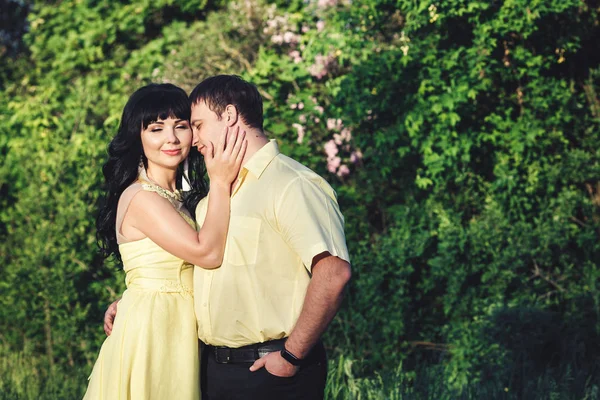 Casal amoroso está de pé no parque no verão e abraçando — Fotografia de Stock