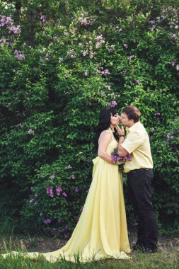 adam ve kız çiçek açması leylak ortasında parkta öpüşme.