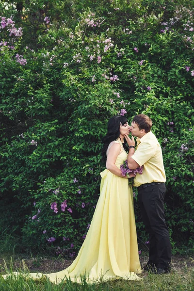 adam ve kız çiçek açması leylak ortasında parkta öpüşme.