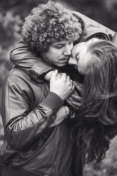 Curly-haired mustachioed man and brown-haired woman hugging in autumn. — Stock Photo, Image