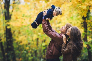 Parkta genç mutlu aile Güz. Babası sevinçle oğlunun atar.
