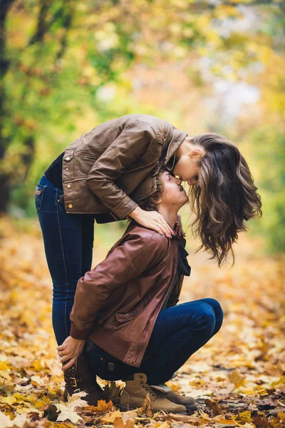 Młoda miłość para jesienią w parku. Dziewczyna całuje faceta w nos. — Zdjęcie stockowe