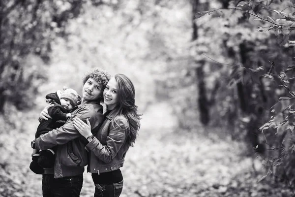 Sonbaharda parkta sarılma genç mutlu aile. — Stok fotoğraf